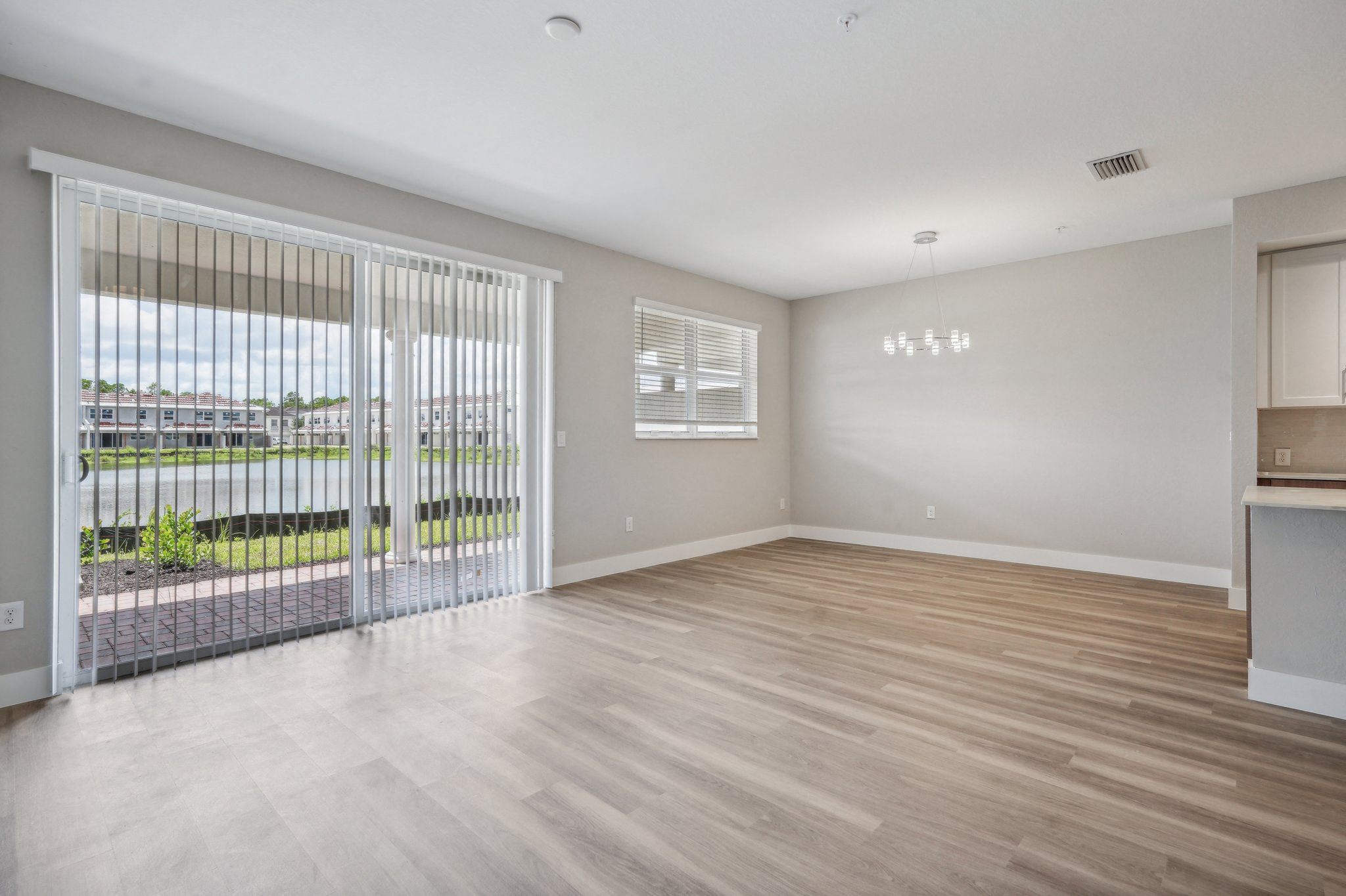 the living room of an apartment with a large window and a sliding glass door